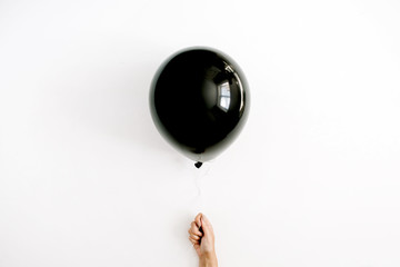 Halloween minimal concept. One black balloon in girl's hand. Flat lay, top view. © Floral Deco