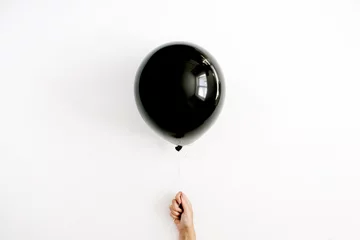 Deurstickers Halloween minimal concept. One black balloon in girl's hand. Flat lay, top view. © Floral Deco