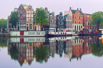 Fototapeta na wymiar Amsterdam canal Amstel with typical dutch houses and houseboat from the boat in the morning, Holland, Netherlands.