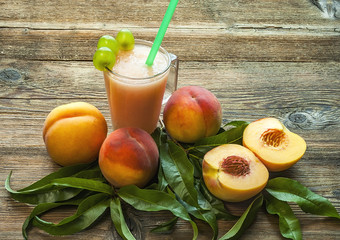 Peaches and peach smoothies. Wood surface.