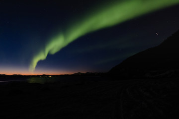 Aurora borealis above snowy islands of Lofoten,Norway on dark foreground.