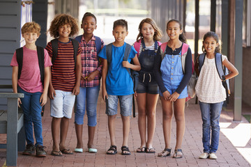 Portrait of kids standing in elementary school hallway