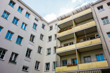 white facaded apartment building with yellow balconies