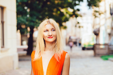 Close up Cheerful Blond Young Woman In Bright Red Clothes at the Street, with Toothy Smile.
