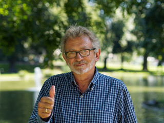 Aktiver Rentner im Park hält den Daumen hoch