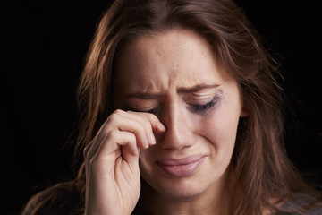 Studio Shot Of Crying Young Woman With Smudged Eye Make Up