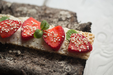 Crisp bread with strawberry, sesame and mint leaves 