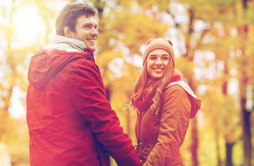 Fototapeta premium happy young couple walking in autumn park