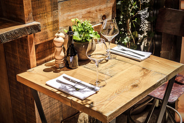 Table in the restaurant in the open air with glasses of wine.