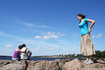 Jealous woman looking at embracing couple. 