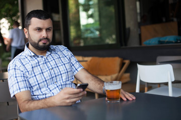Fototapeta na wymiar Handsome man sitting and thinking in bar