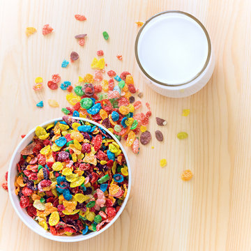 Kids healthy quick breakfast. Colorful rice cereal with milk on wooden background. Copy space. Selective focus. Square image