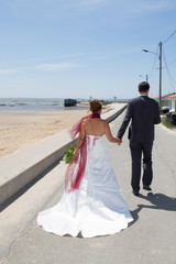 Fototapeta na wymiar Rear view of wedding romantic couple near the ocean