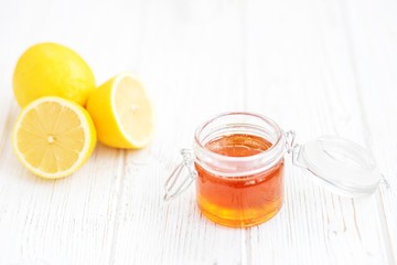 Honey in a glass jar and a lemon. Place for the inscription. The concept of healthy food, vegetarianism, autumn, colds,  treatment, cure, therapy, medication.
