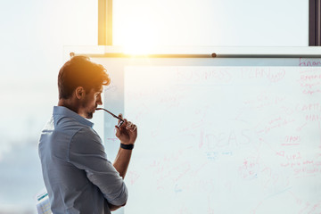 Entrepreneur putting his business ideas on whiteboard in boardro