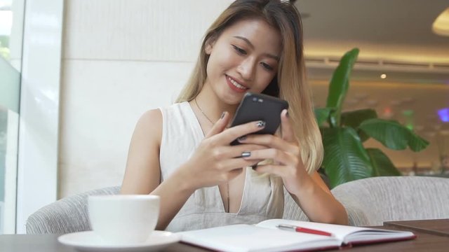 Asian woman texting on cellphone