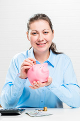 Thrifty woman and piggy pink vertical portrait