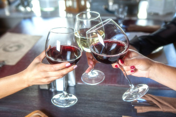 happy friends in a bar drinking red wine.