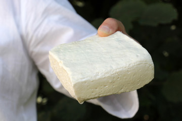 woman hadn holding block of sheep cheese