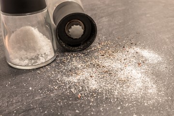 Salz und Pfeffer Mühle mit Salz und Pfeffer auf einer grauen Arbeitsplatte