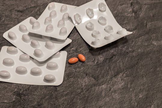 Tabletten einzeln  und in Blister Verpackungen auf einer grauen Arbeitsplatte