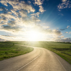 Fototapeta premium sunset in clouds over asphalt road to horizon