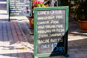Blackboard at a restaurant with the lunch menu offers including minced beef, chgeese, vegetarian,...
