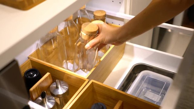 Pick up empty bottle from rack in the kitchen