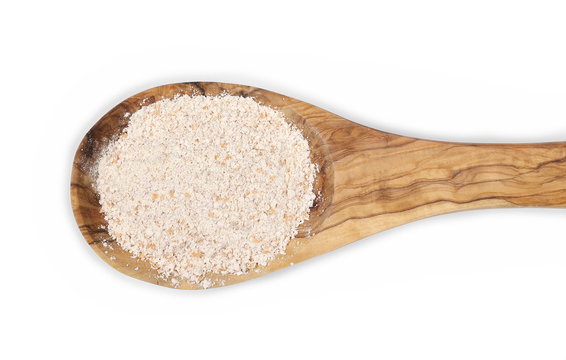 Pile of integral spelt wheat flour in wooden spoon isolated on white