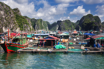 Fototapeta na wymiar traditional vietnamese boats and floating village among beautiful limestone rocks of Lan Ha bay, the southern edge of Ha Long bay, Vietnam
