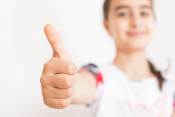 Little girl with thumb raised in sign of approval