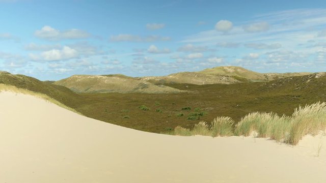 Wonderful beach with valle surrounded by dunes in the background on a sunny day