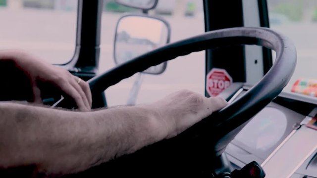 Driver driving a truck with his hands on the steering wheel