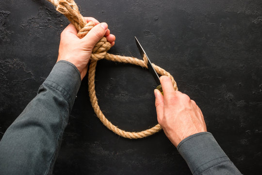 Man cuts with a knife suicide rope loop