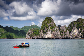 Fototapeta na wymiar boats among beautiful limestone rocks of Lan Ha bay, the twin of Ha Long bay ona sunny day, Vietnam