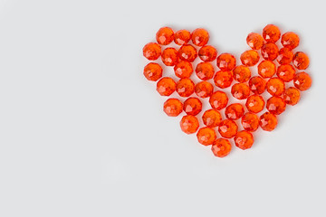 Heart of red beads on a white background