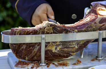 Waiter is slicing raw ham,italian