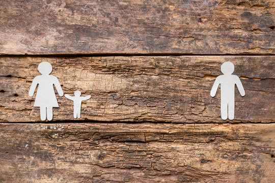 Paper family on a wooden background - child with mother after a divorce