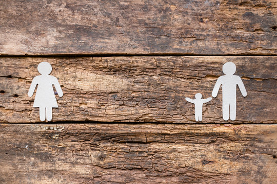 Paper family on a wooden background - a child with a father after a divorce