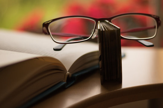 Common things of a teacher: glasses and books lie on a desk. Concept: hello Teacher's Day!  