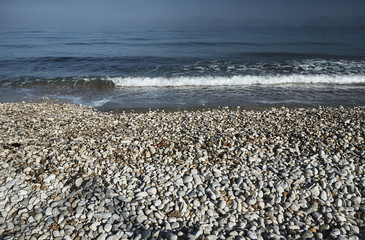Pebbles on a sandy beach on the island of Corfu .