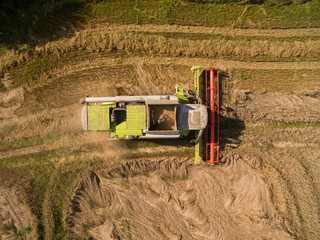 combine harvester - Aerial view of modern combine harvester at the harvesting the wheat on the...