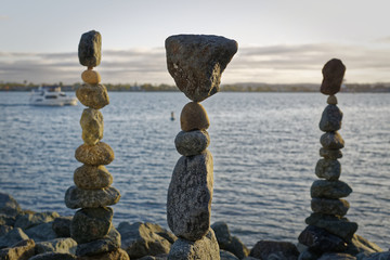The art of Rock balancing with water, ship and sky in the background	