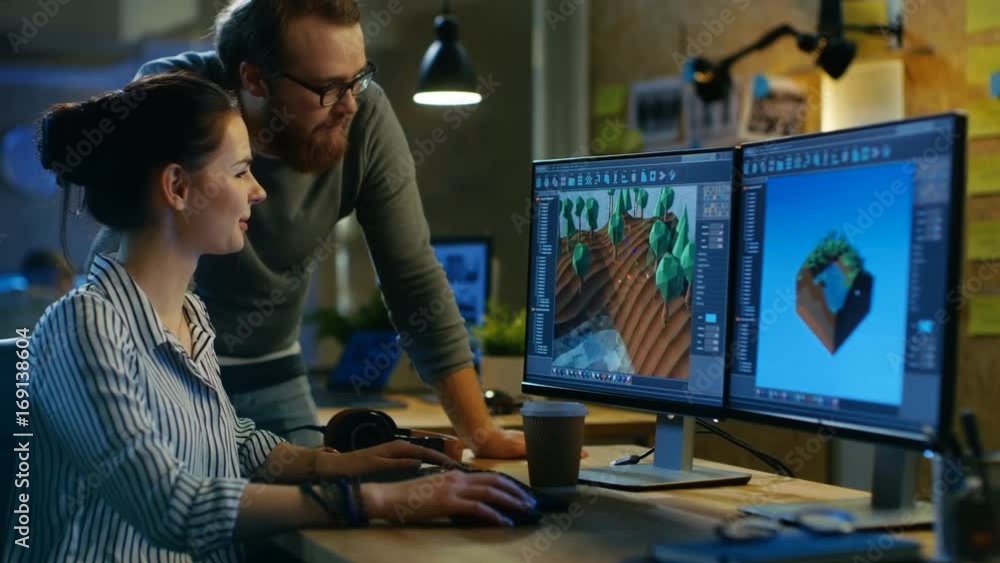 Poster Female Game Developer Has Discussion with Male Project Manager While Working on a Game Level on Her Personal Computer with Two Displays. They Work in a Modern Loft Office Creative Environment. 