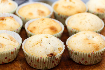 Tasty muffins colored paper on a wooden table