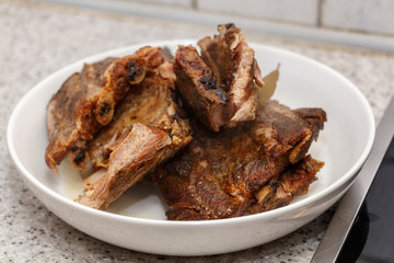 Dried smoked pieces of meat on a white plate