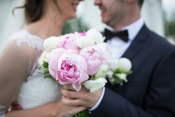 Obraz na płótnie Canvas Bride and groom with a beautiful purple wedding bouquet