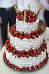 Vertical shot of a red and white wedding cake with fresh strawberries decoration