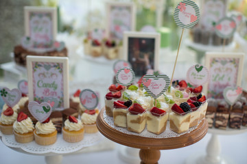Small white and green cakes at a wedding candy bar