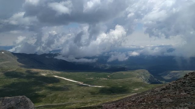 Colorado mountains in Fairplay in cloudy day and passing cars through gravel roar in time lapse.